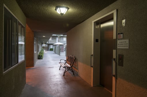 a bench sits on a patio outside a building with an open door