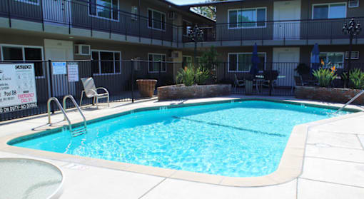 A small pool in front of apartment building.