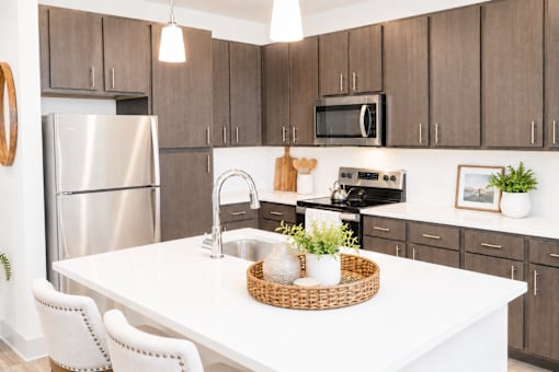 A kitchen with a white table and brown cabinets.