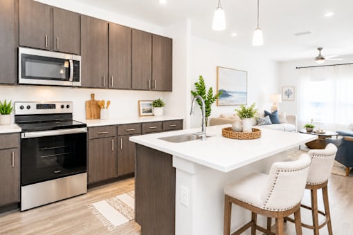 A modern kitchen with a white island and wooden cabinets.