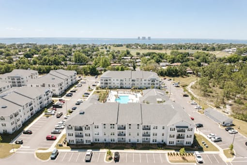 A large white building with a pool in the middle of a parking lot.