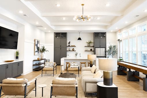 A modern living room with a large sofa set, a coffee table, and a TV on the wall.