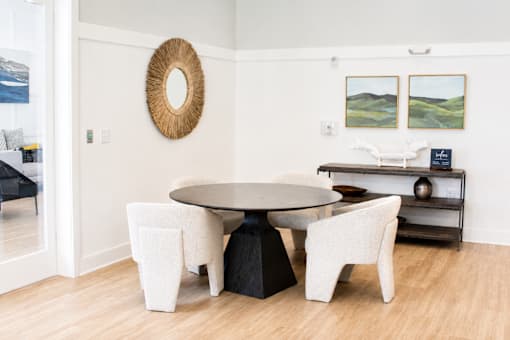 A white dining room with a round table and chairs.