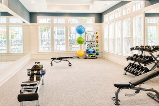 A gym with a variety of equipment including weights and exercise balls.