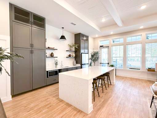 A kitchen with a white island and wooden floors.