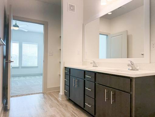A bathroom with a sink, mirror, and cabinets.