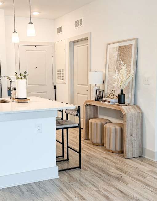 A white kitchen with a wooden island and a bench.