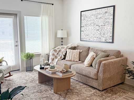 A living room with a couch, a table, and a plant.