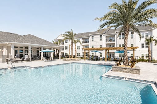 A large swimming pool in front of a resort.