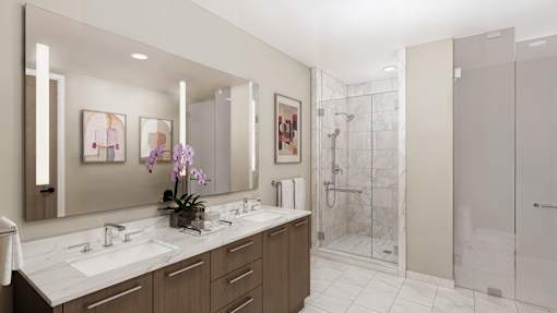 A bathroom with a double sink vanity and a walk-in shower.