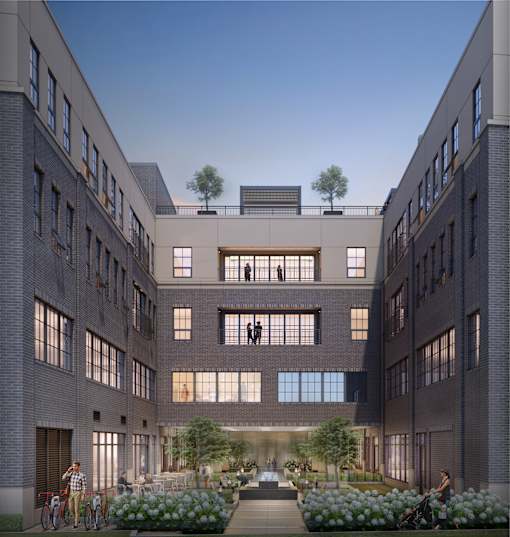 A modern courtyard surrounded by buildings with people walking and riding bicycles.