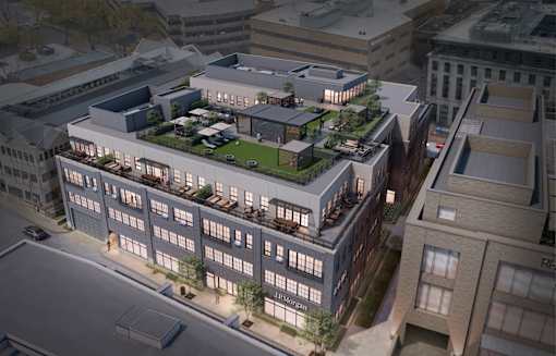 A modern building with a green roof is shown in an aerial view.