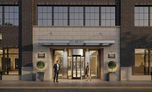 Two people stand outside a building with the number 370 on it.