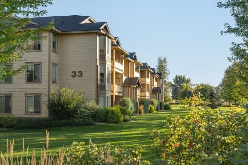 a row of townhomes with grass and trees