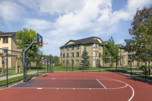 a basketball court in front of an apartment building