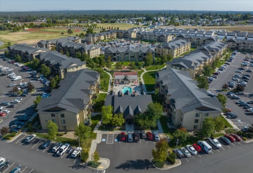 an aerial view of an apartment complex with cars parked in a parking lot