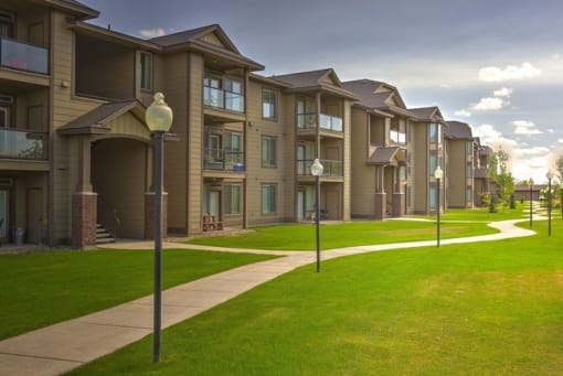 An exterior view of an apartment complex with a green lawn
