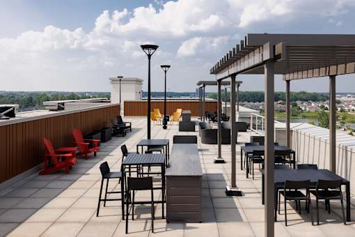 Roodtop patio with tables and chairs overlooking a cityscape at 1600 Hyde Park Village Apartments, London