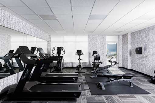 A gym with treadmills, exercise bikes, and other equipment at 1600 Hyde Park Village Apartments, London