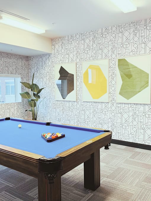 A pool table with a blue cloth and a white ball on it.