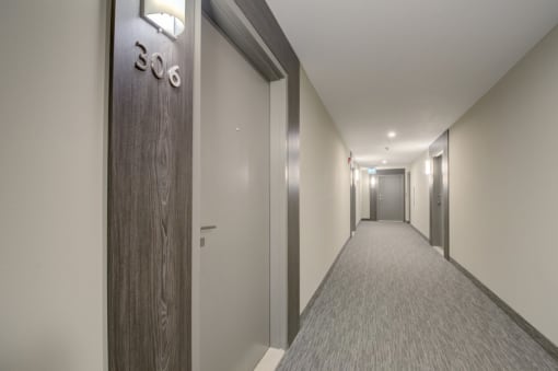 a hallway with a wooden door and a number on the wall