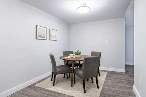 A dining room with a table and chairs.