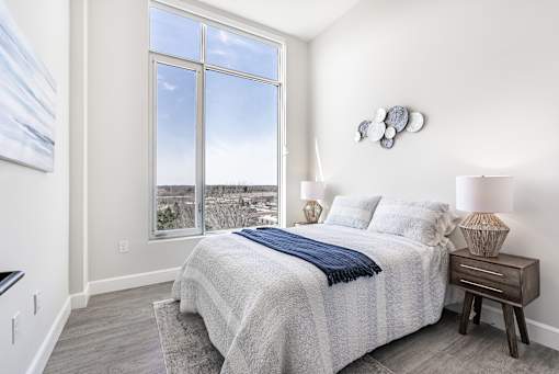 A bedroom with a large bed and a view of the city.