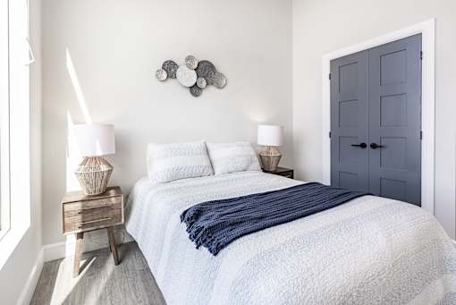A bedroom with a bed, nightstand, and lamp.