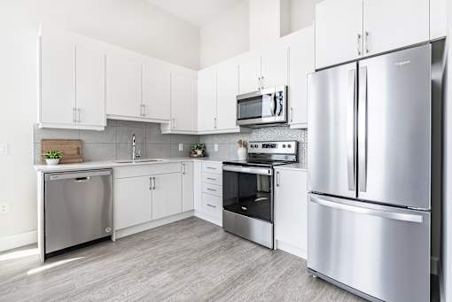 A modern kitchen with stainless steel appliances and white cabinets.