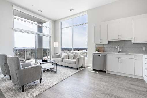 A modern living room with a grey sofa and a grey armchair.