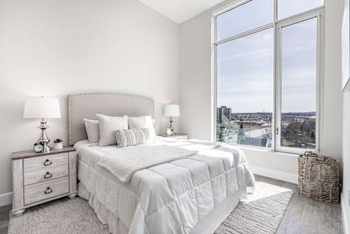 A bedroom with a large bed and a view of the city.