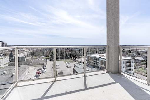 A view from a high balcony looking out over a parking lot and buildings.
