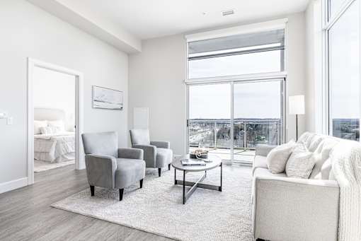 A living room with a large window and a view of the city.