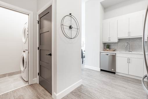 A modern kitchen with a washer and dryer in the laundry room.
