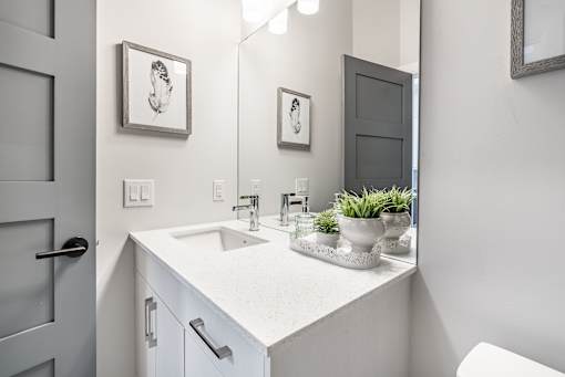A bathroom with a white sink and a mirror.