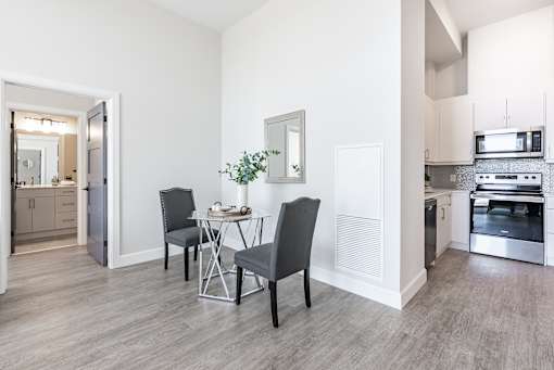 A kitchen with a dining table and chairs.