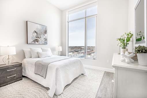 A bedroom with a large bed and a view of the city.