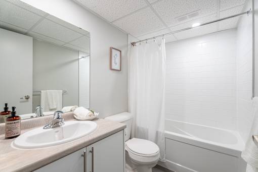 A white bathroom with a sink, toilet, and bathtub  at Platts Crossing, London, ON, N6H 4P4