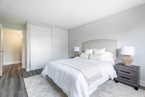 A bedroom with a large bed and a nightstand with a lamp  at Platts Crossing, London, ON, N6H 4P4