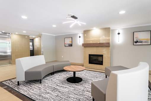 A modern living room with a fireplace and grey couches  at Platts Crossing, London, ON, N6H 4P4