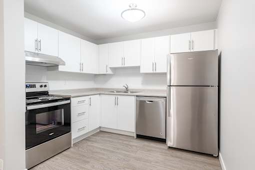 A modern kitchen with stainless steel appliances and white cabinets.
