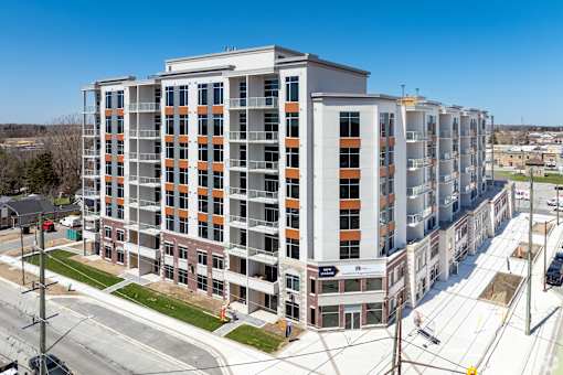 A large multi-story building with orange and white balconies.