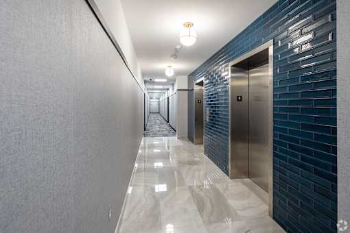 A long hallway with a series of elevators on the right.