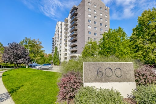 a large stone sign with the number 60 on it in front of an apartment building