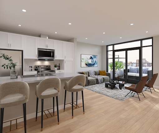 A modern kitchen with white cabinets and a bar area with stools.