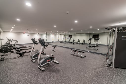 a large fitness room with treadmills and other exercise equipment