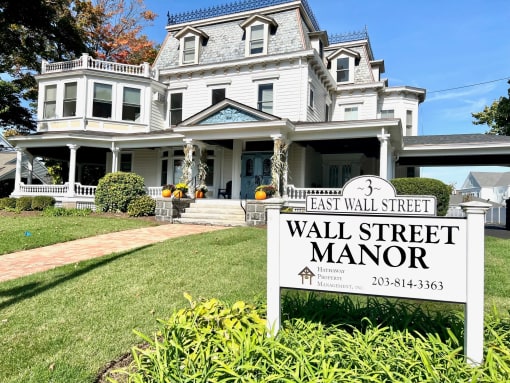 a large white house with a sign that reads wall street manor