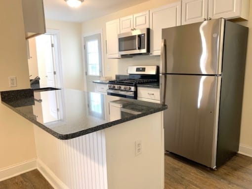 a kitchen with a stove a refrigerator and a microwave
