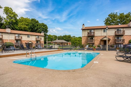 A swimming pool in a residential area surrounded by apartment buildings.
