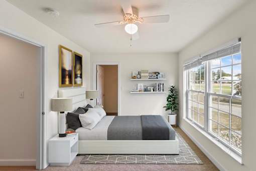 a bedroom with a bed and a ceiling fan